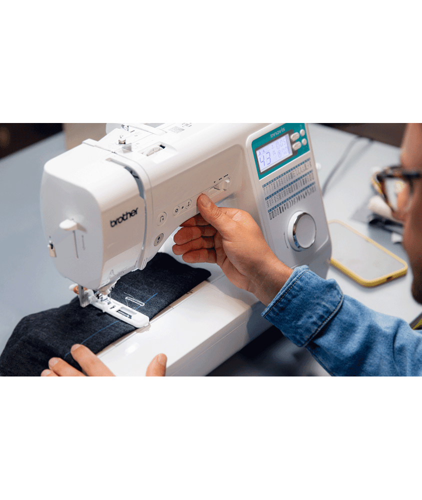 Machine à coudre Brother Innov-is A65 en situation de couture avec son panneau turquoise