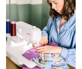 Couturière au travail avec la recouvreuse Bernina L 620