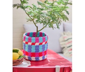 Cache-pot Lecce crocheté en damier rose, rouge, bleu et violet, avec un mimosa planté dedans - Patron crochet Pingouin