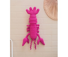 Homard Salerne crocheté en rose vif, suspendu sur un mur clair, 40 cm de long - Patron crochet Pingouin