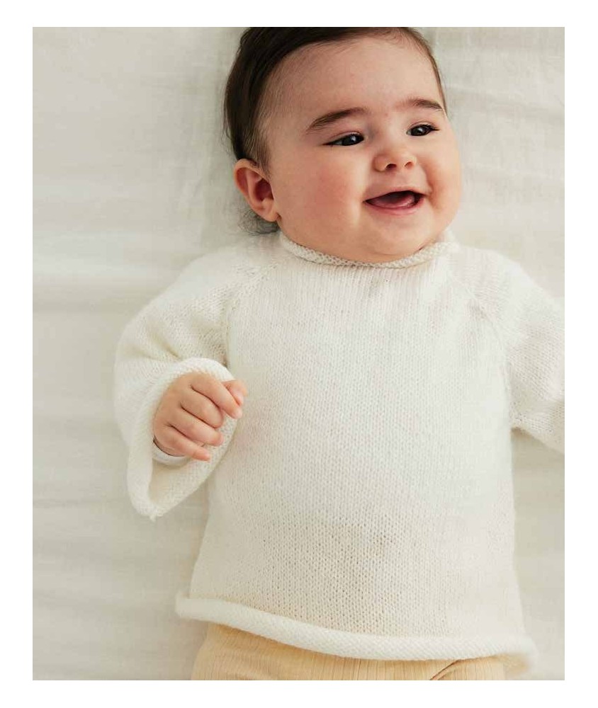 Brassière Bonny tricotée en jersey blanc cygne, col roulotté, sur un bébé allongé - Patron tricot Phildar