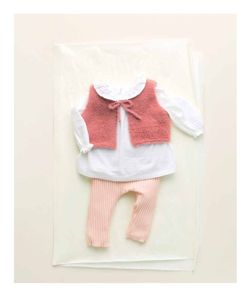 Gilet Zalie sans manches en fil duveteux rose, posé à plat sur une chemise blanche - Patron tricot Phildar