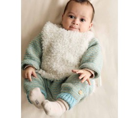 Plastron Ugo en fausse fourrure écru, porté sur un gilet, sur un bébé allongé - Patron tricot Phildar