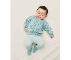 Pull Xavius tricoté en laine mouchetée bleu turquoise sur un bébé allongé - Patron tricot Phildar