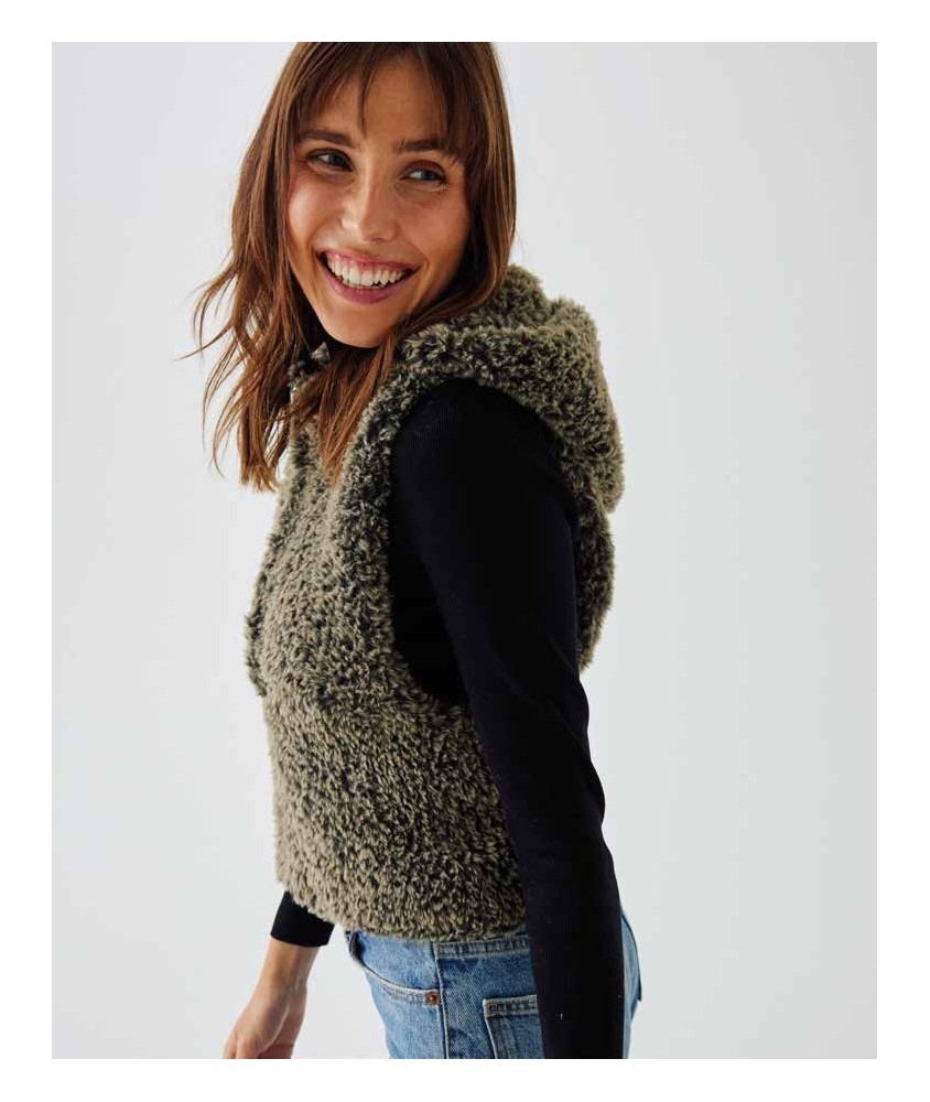 Gilet sans manches Izia tricoté en fausse fourrure vison, porté sur un haut noir - Patron tricot Phildar