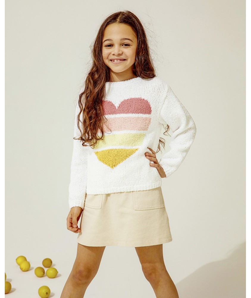 Pull Dahlia blanc orné d'un grand cœur en jacquard dégradé rose et jaune, porté par une fillette - Patron tricot Phildar