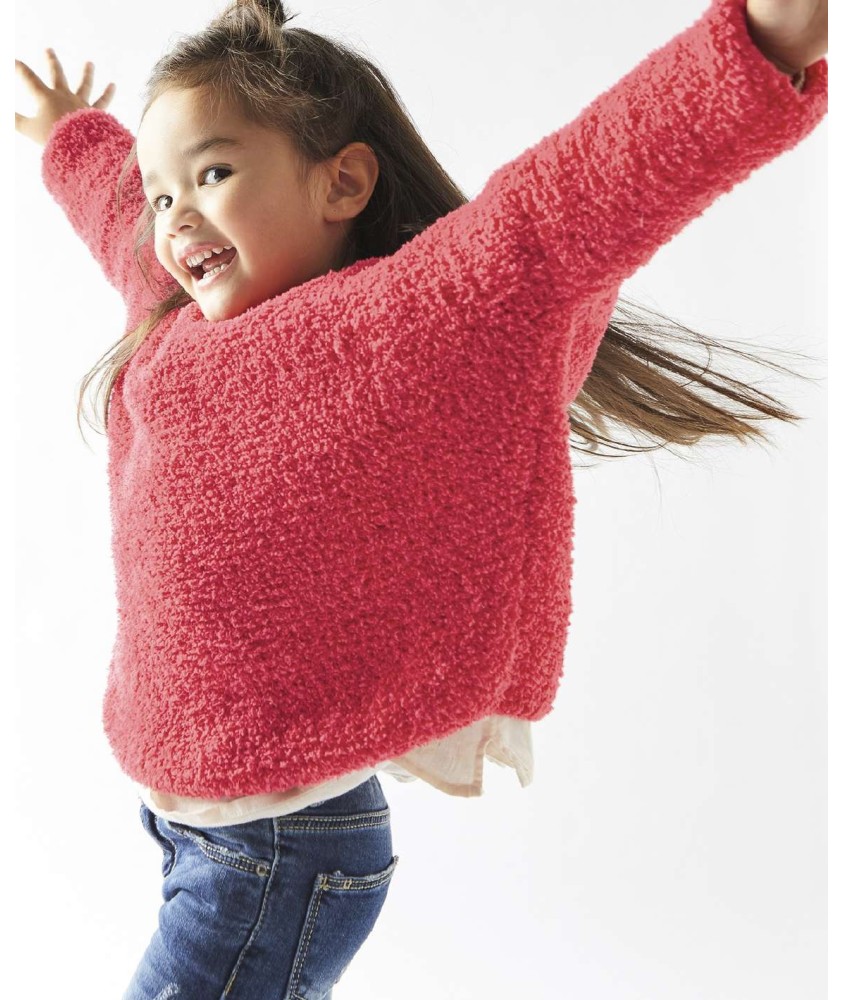 Pull Ninon framboise en fil bouclette, jersey envers, porté par une petite fille bras levés - Patron tricot Phildar