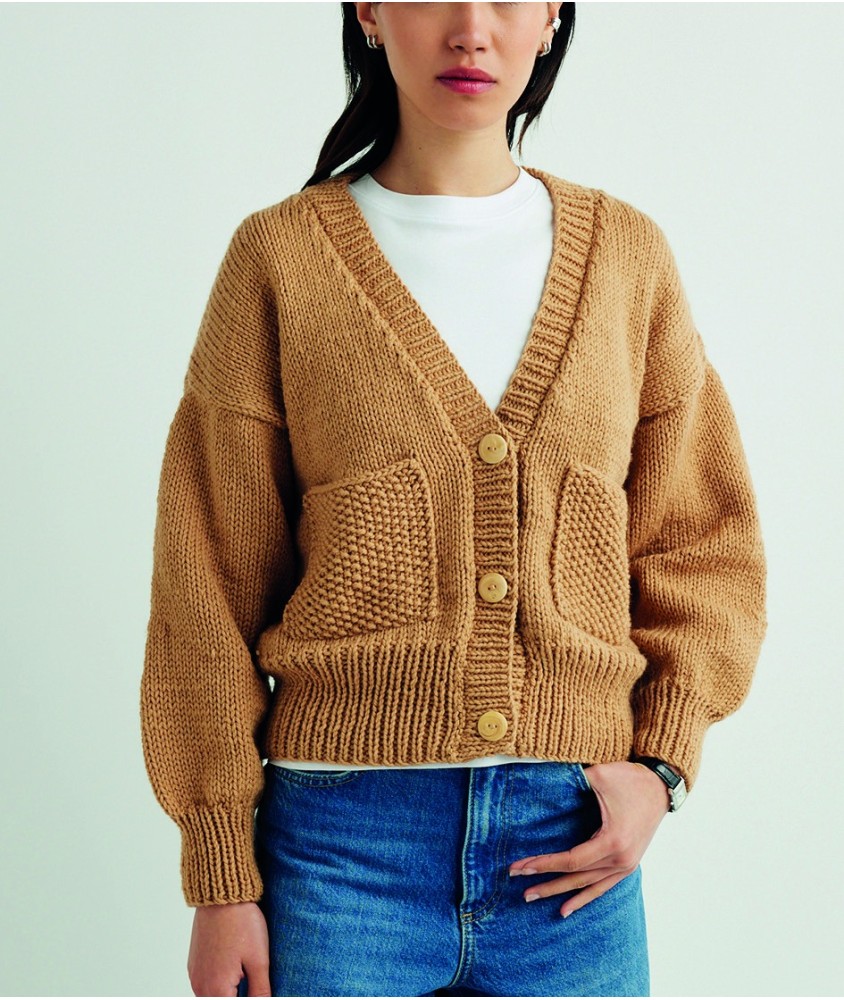Gilet Svea camel à col V, poches plaquées et boutons, porté par une femme - Patron tricot Pingouin
