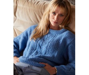 Pull Sania bleu océan à torsades et point de riz, en laine mérinos, porté par une femme - Patron tricot Phildar