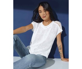 Pull Ramona blanc en lyocell, jersey et pattes d'épaules ajourées, porté par une femme - Patron tricot Phildar