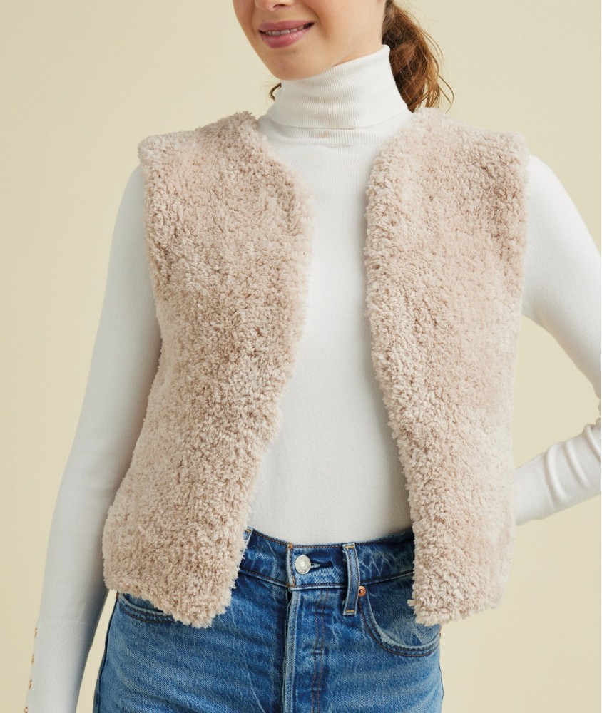 Gilet sans manches Marty beige en fil duveteux, porté ouvert sur un col roulé - Patron tricot Pingouin